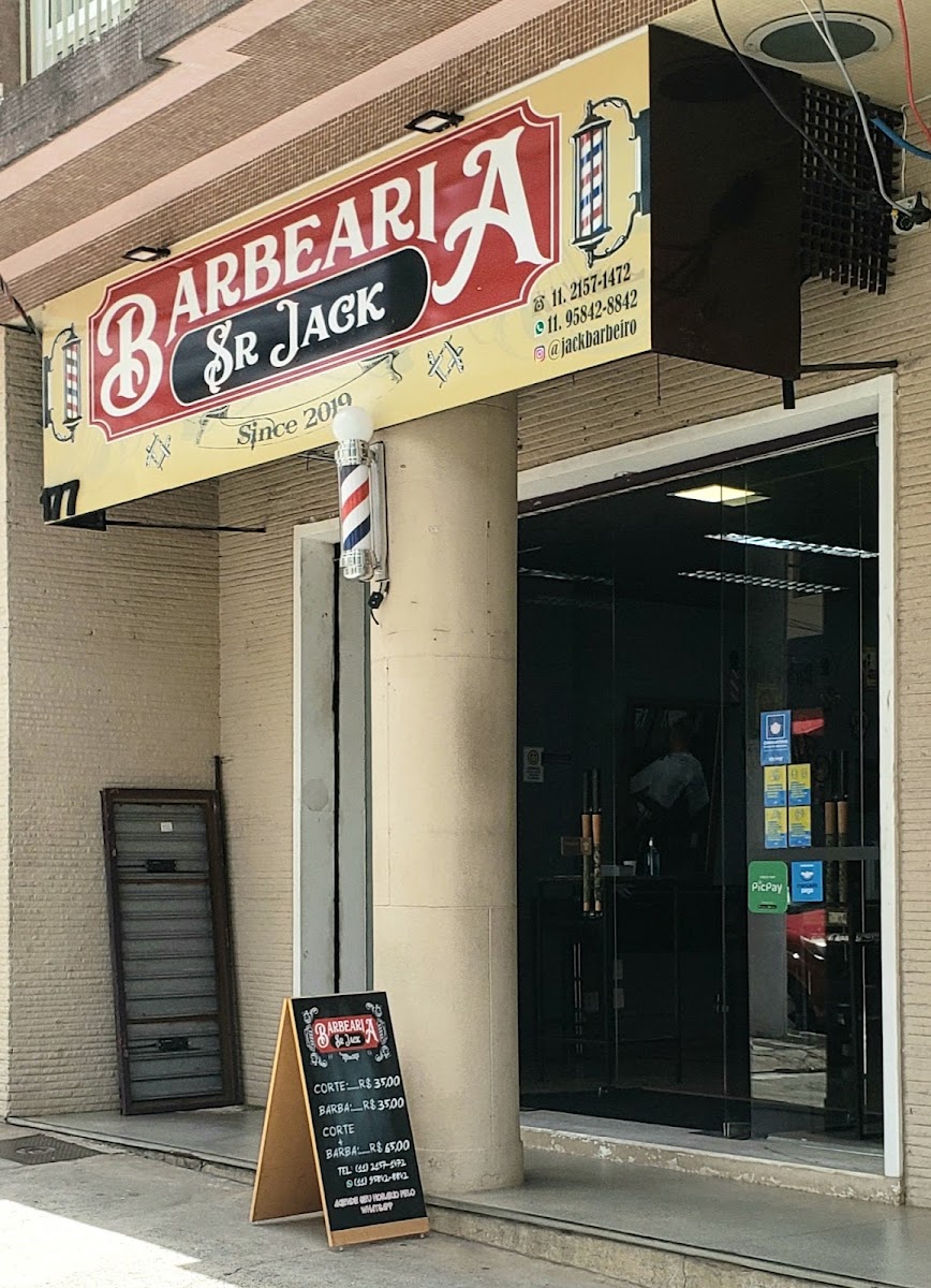 Fachada da barbearia com letreiro e poste de barbeiro
